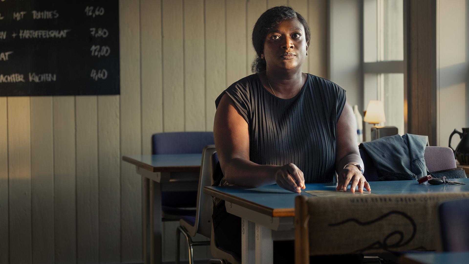 "Die Polizistin und die Sprache des Todes": Pieper Olsen (Artjom Gilz) und Gloria Acheampong (Thelma Buabeng) stehen neben einem Polizeiwagen und geben sich die Hand.