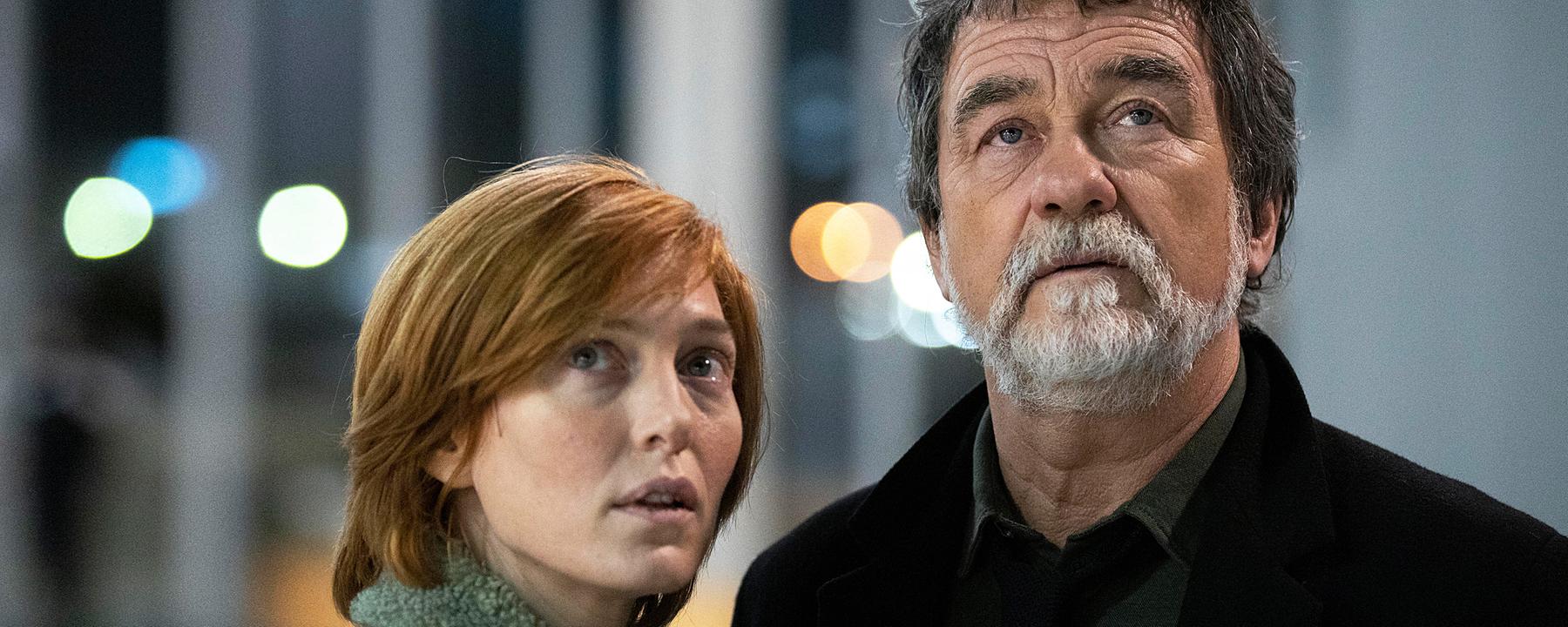 Camille Delaunay (Erika Sainte) und Pierre Niémans (Olivier Marchal) stehen nebeneinander und sehen nach oben.