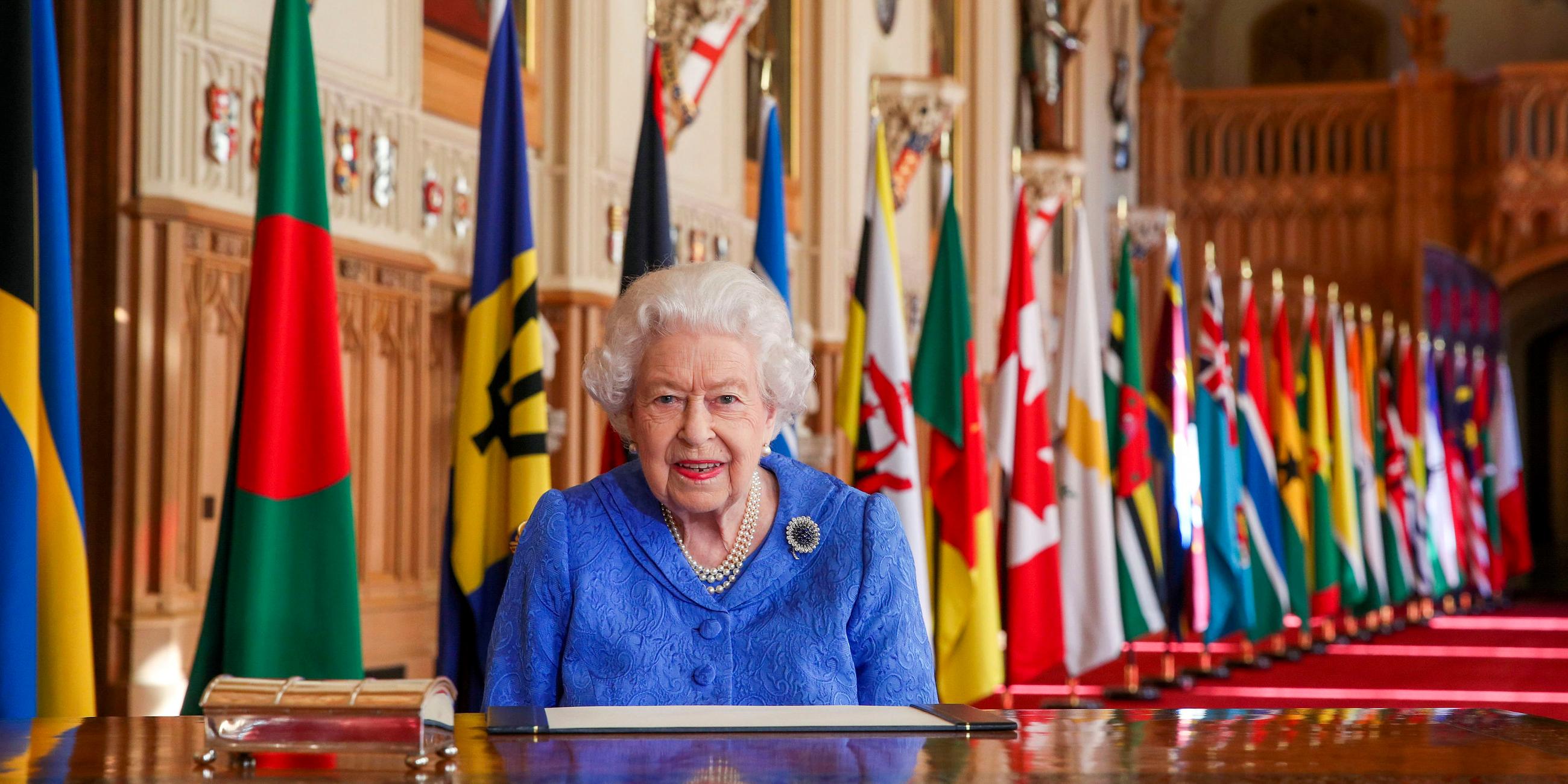 Commonwealth Day 2021: Die Queen vor verschiedenen Länderflaagen an einem Schreibtisch