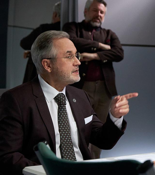 David Schreiber (Norbert Heckner) sitzt mit Kommissarin Winter (Vanessa Eckart) an einem weißen Tisch im Vernehmungsraum und redet, während er mit dem Zeigefinger auf die Kommissarin zeigt. Im Hintergrund steht Kommissar Stadler (Dieter Fischer) mit verschränkten Armen, er verfolgt das Geschehen.