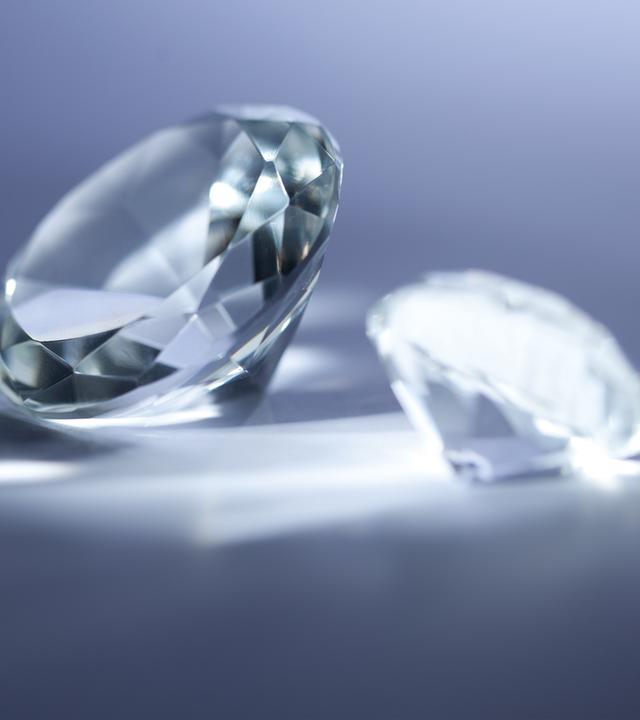 Drei Diamanten liegen auf einer Glasplatte.