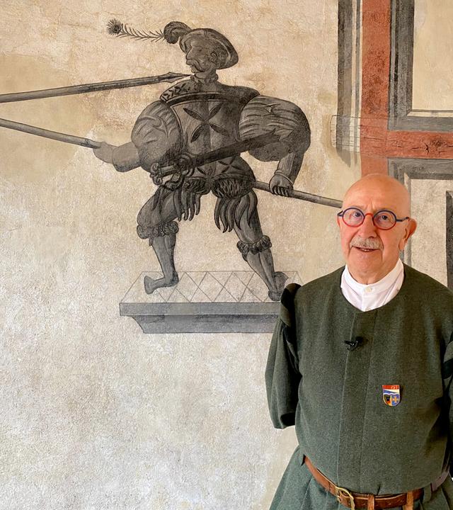 Älterer Herr in Tracht vor Wandgemälde 
