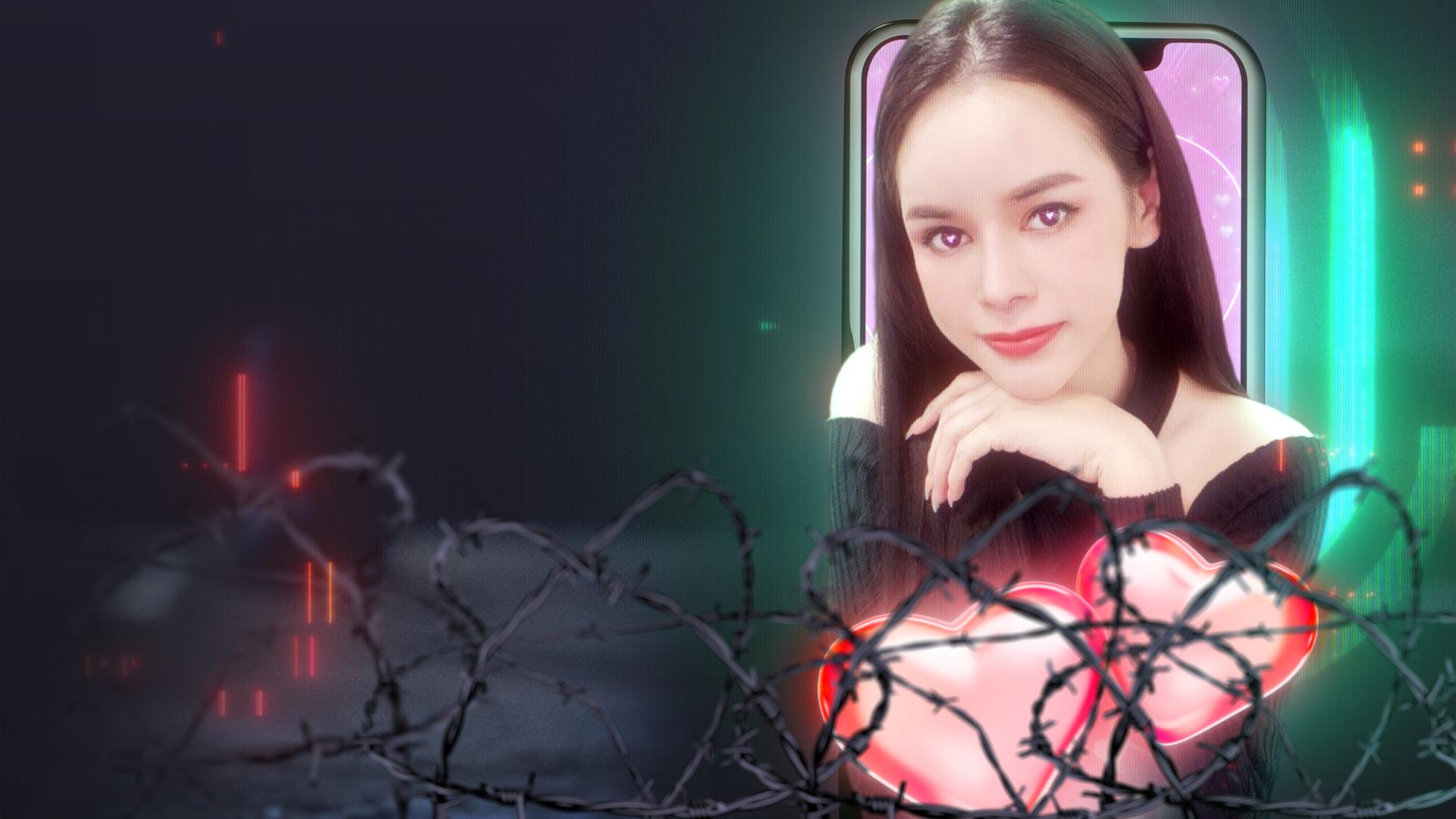 Frau vor Drahtzaun, schaut aus Handy heraus