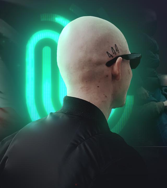 Mann mit Glatze und 444 Tattoo von der Rücksite, vor Spur-Logo und Reichsflagge sowie rechten Demonstrierenden 