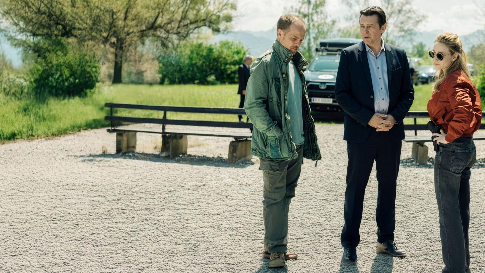 "Die Toten vom Bodensee - Atemlos": Micha Oberländer (Matthias Koeberli), Thomas Komlatschek (Hary Prinz) und Luisa Hoffmann (Alina Fritsch) stehen draußen auf einem Parkplatz zusammen und unterhalten sich.