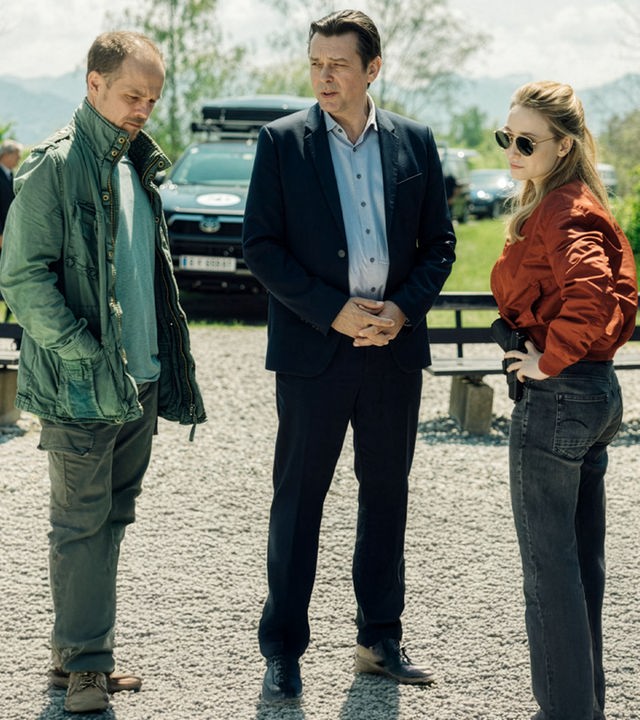 "Die Toten vom Bodensee - Atemlos": Micha Oberländer (Matthias Koeberli), Thomas Komlatschek (Hary Prinz) und Luisa Hoffmann (Alina Fritsch) stehen draußen auf einem Parkplatz zusammen und unterhalten sich.