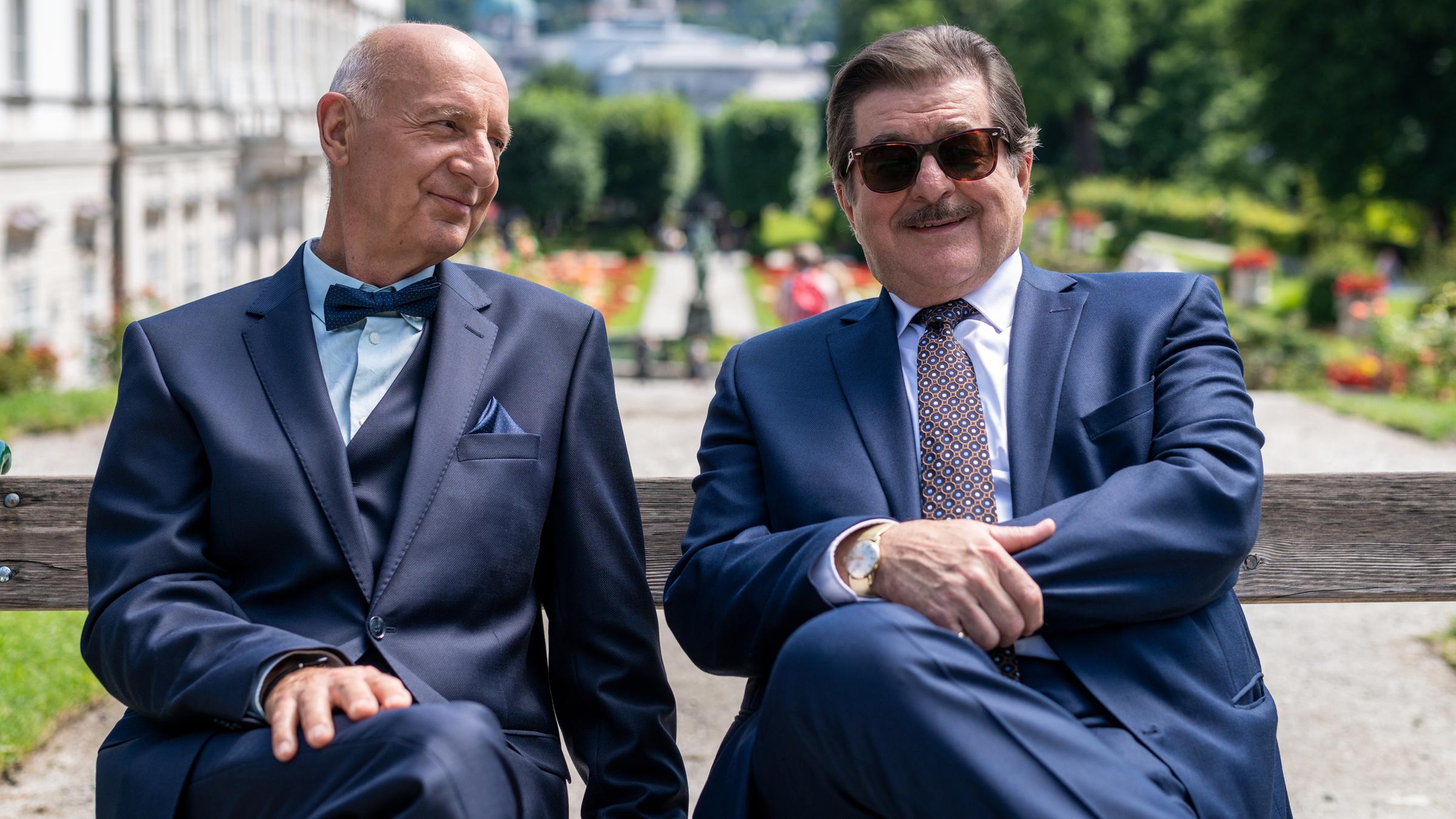 Alfons Seywald (Erwin Steinhauer) und René Kleist (Michael Schönborn) sitzen auf einer Bank und unterhalten sich. Im Hintergrund ein Park.