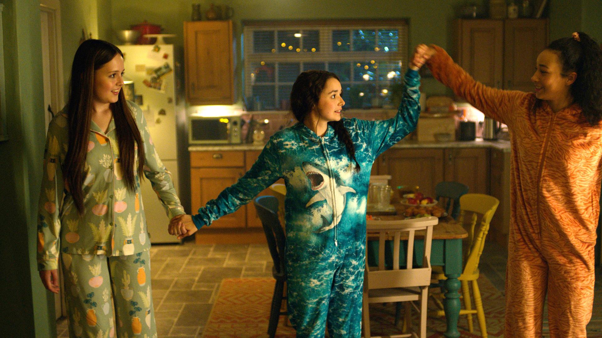 Übernachtungsparty mit Jenna, Addie und Audrey: Alle drei stehen im Schlafanzug in der Küche und halten sich an den Händen. 