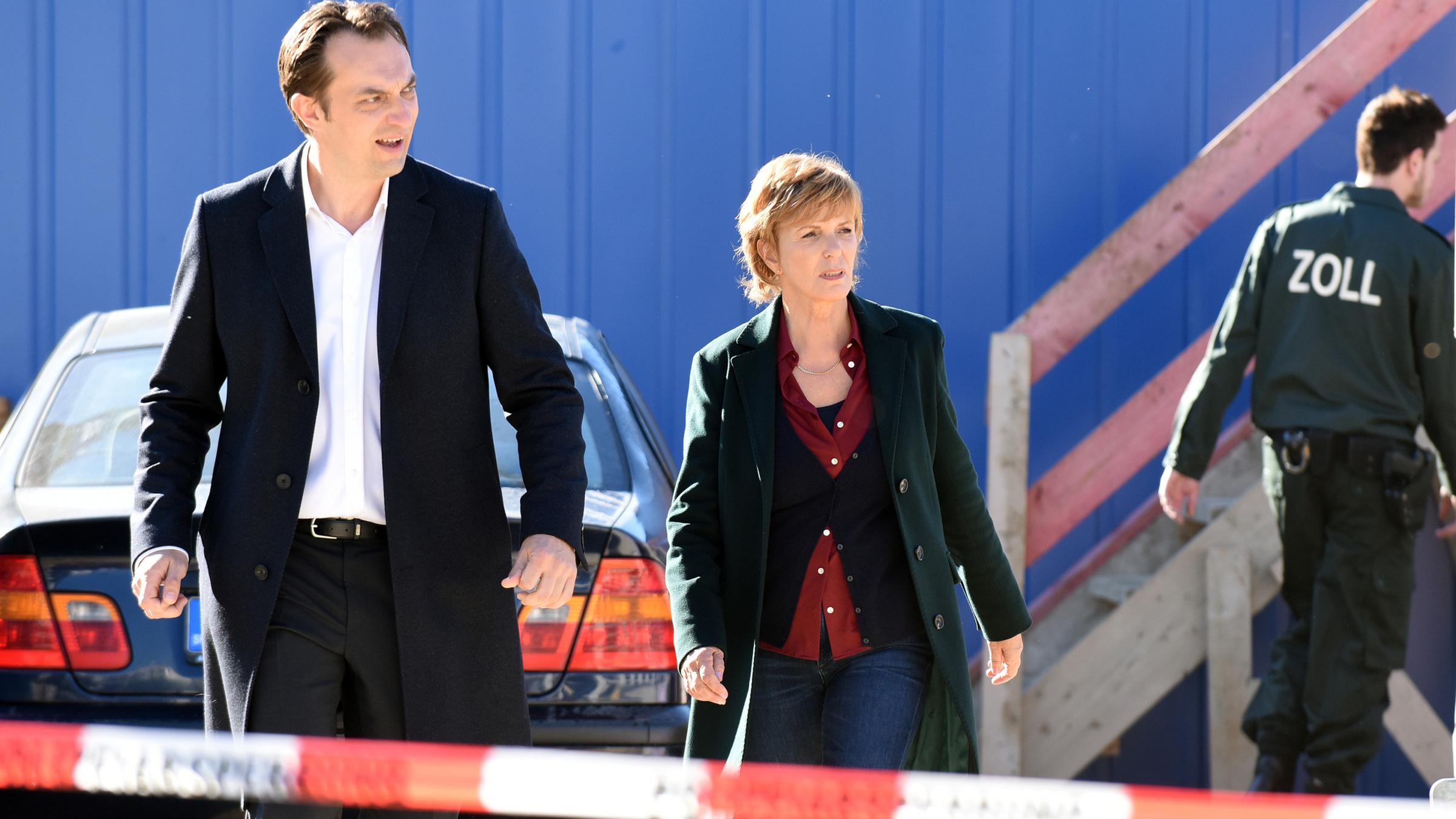Auf einer Baustelle laufen Staatsanwalt Walch (Steven Scharf) und Kommissarin Lucas (Ulrike Kriener) zum Tatort, vor ihnen ist ein Absperrband zu sehen. 
