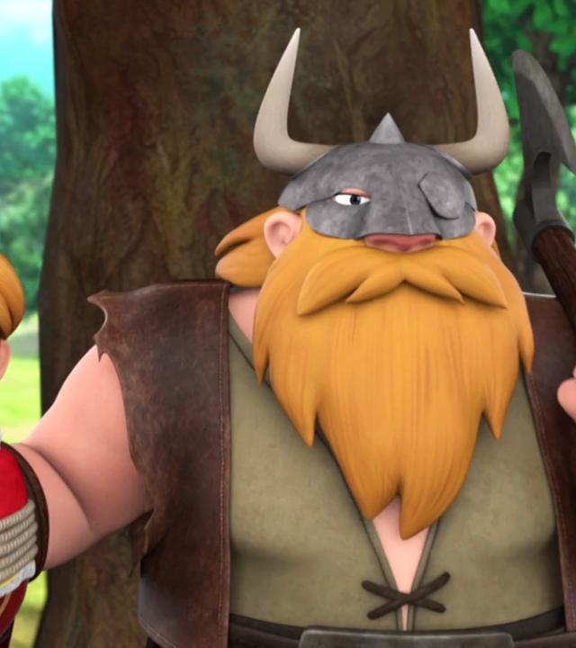 Prinz John (links) ist mit einem Seil gefesselt, der Mund wurde ihm zugeklebt. Rechts neben ihm steht ein Wikinger mit langem Bart, den rechten Arm hat er um Prinz John gelegt, mit der linken Hand stützt er eine Axt auf seine Schulter. Er trägt einen Helm.