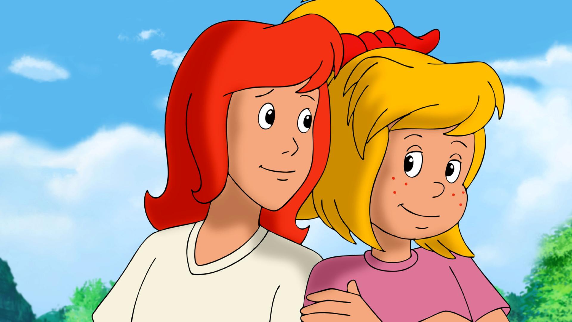 Tina und Bibi stehen Schulter an Schulter und lächeln sich an.