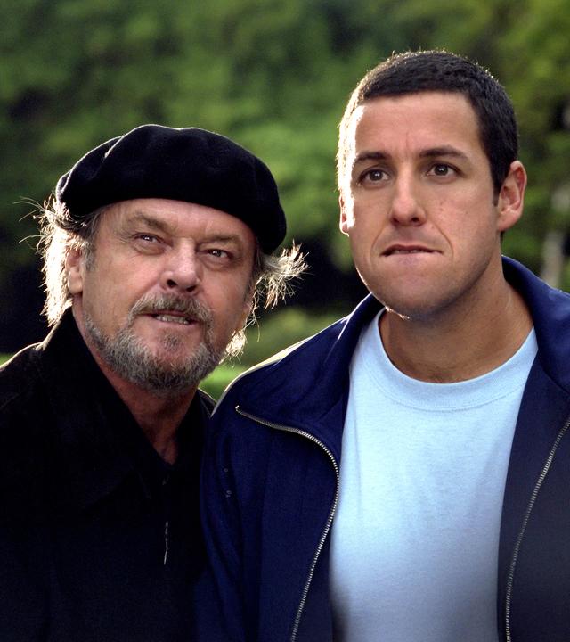"Die Wutprobe": Dr. Buddy Rydell (Jack Nicholson) und Dave Buznik (Adam Sandler) stehen eng nebeneinander in einem Park. Beide beißen sich auf die Unterlippe und haben dabei die Augen weit geöffnet.