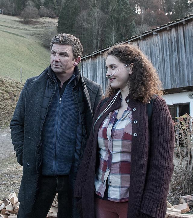 "Der Bergdoktor - Die Zeit, die bleibt (1)": Martin Gruber (Hans Sigl) verfolgt das Gespräch zwischen David (Jonathan Berlin) und Lisa (Fanny Krausz). Sie trägt einen Beatmungsschlauch in der Nase.