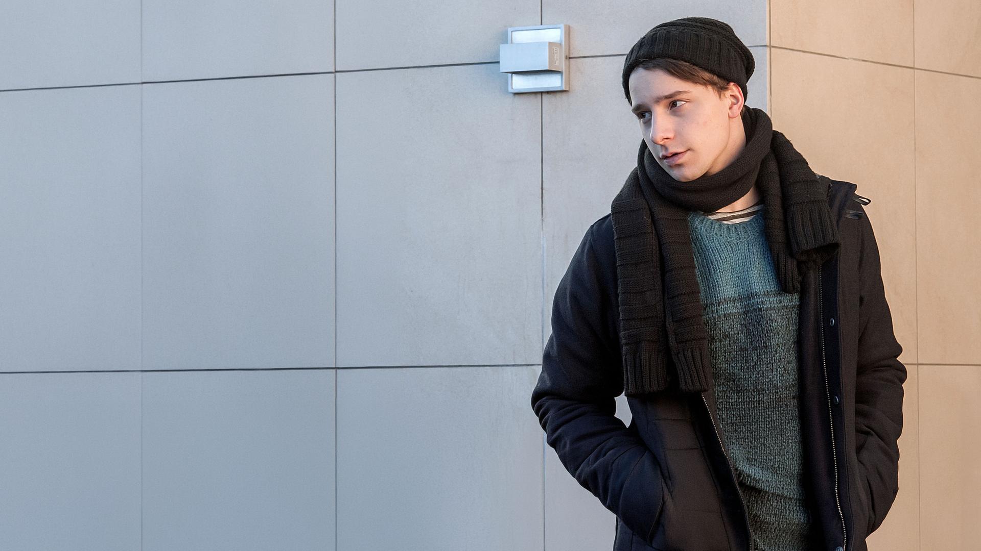 "Der Bergdoktor - Die Zeit, die bleibt (2)": David Richter (Jonathan Berlin) lehnt winterlich gekleidet an einer Wand.