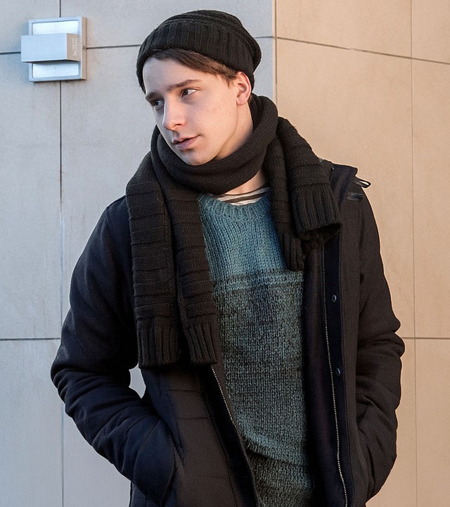 "Der Bergdoktor - Die Zeit, die bleibt (2)": David Richter (Jonathan Berlin) lehnt winterlich gekleidet an einer Wand.