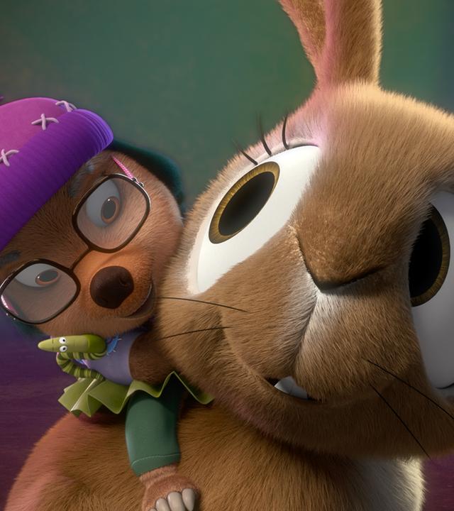 Dotty sitzt auf dem Rücken eines großen, braunen Hasen und hält sich an seinem Hals fest. Der Hase dreht sich mit freundlichem Gesichtsausdruck zu ihr um. 