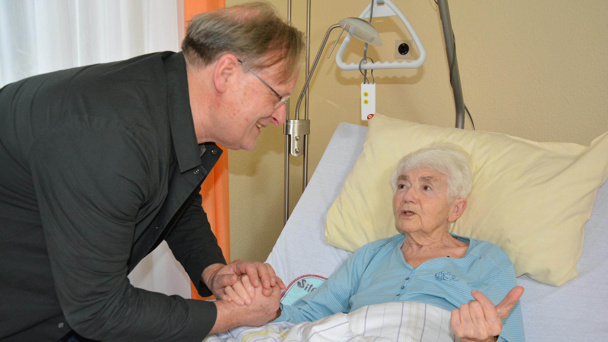 Dietrich Grönemeyer hält die Hand von Gerda Dorowski bei einem Besuch am Krankenbett.