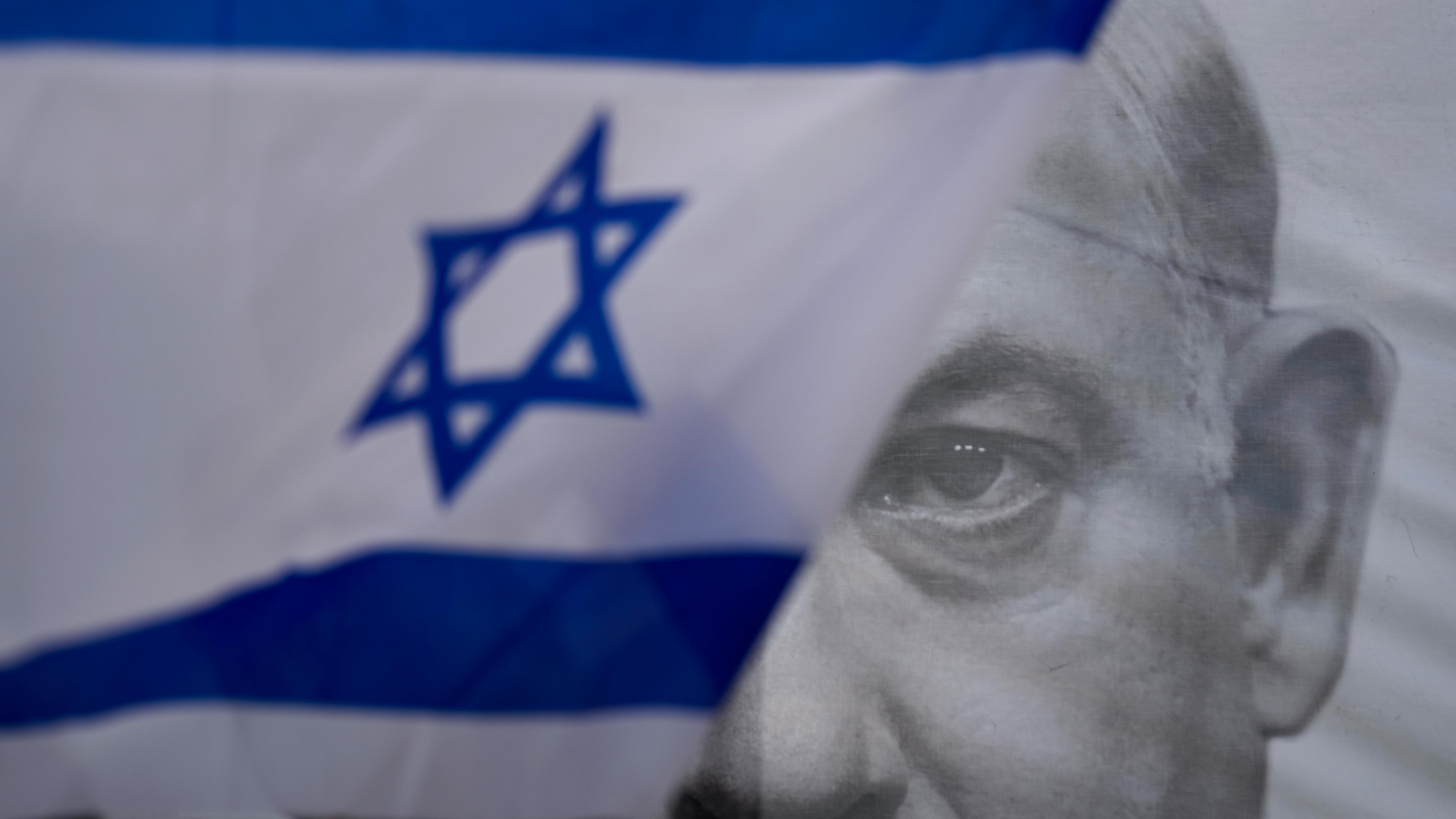 Israelische Nationalflagge vor Porträt von Netanjahu