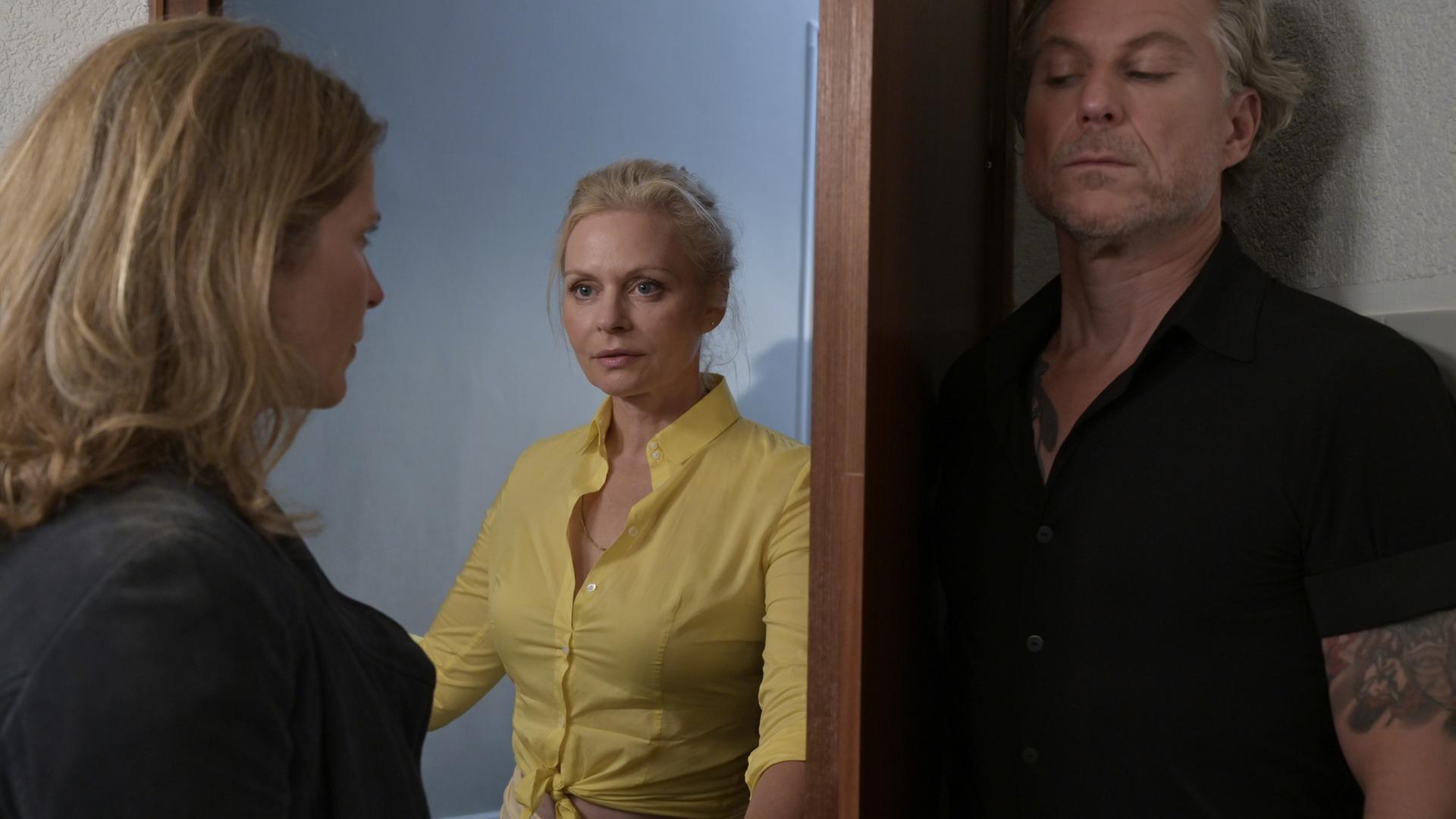 "Nächste Ausfahrt Glück - Song für die Freiheit": Sybille (Susanna Simon) öffnet die Tür zur Damentoilette und trifft auf Katharina (Valerie Niehaus). Juri (Dirk Borchardt) hält sich hinter der Tür versteckt.