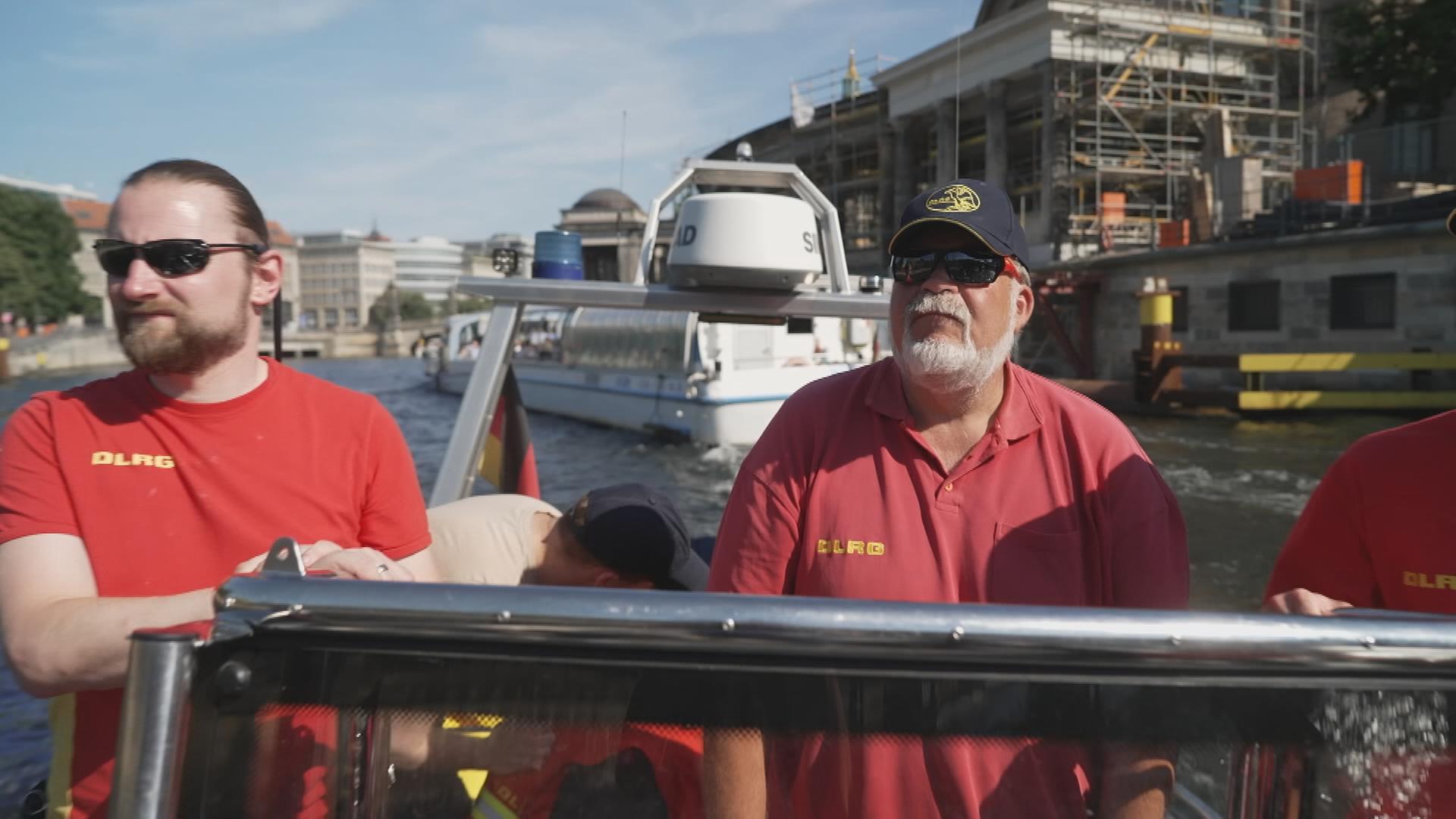 Zwei Männer der DLRG auf einem Boot auf Berlins Wasserstraße.