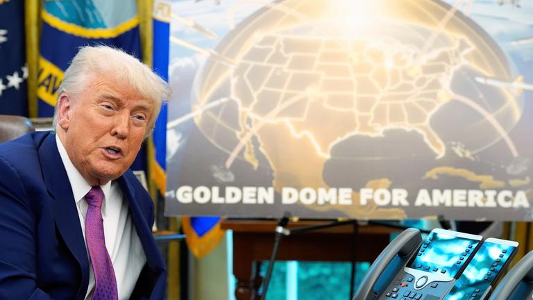 Links Donald Trump, der mit einem Plakat das Raketenabwehrsystem "Golden Dome" vorstellt. Auf dem Plakat ist die USA gold markiert, über den USA ist ein goldener Schirm, der Raketen abhält
