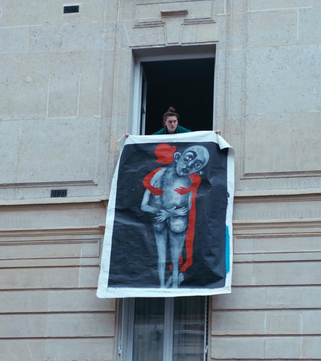 Totale von Frau, die ein großes Bild aus dem Fenster hält.