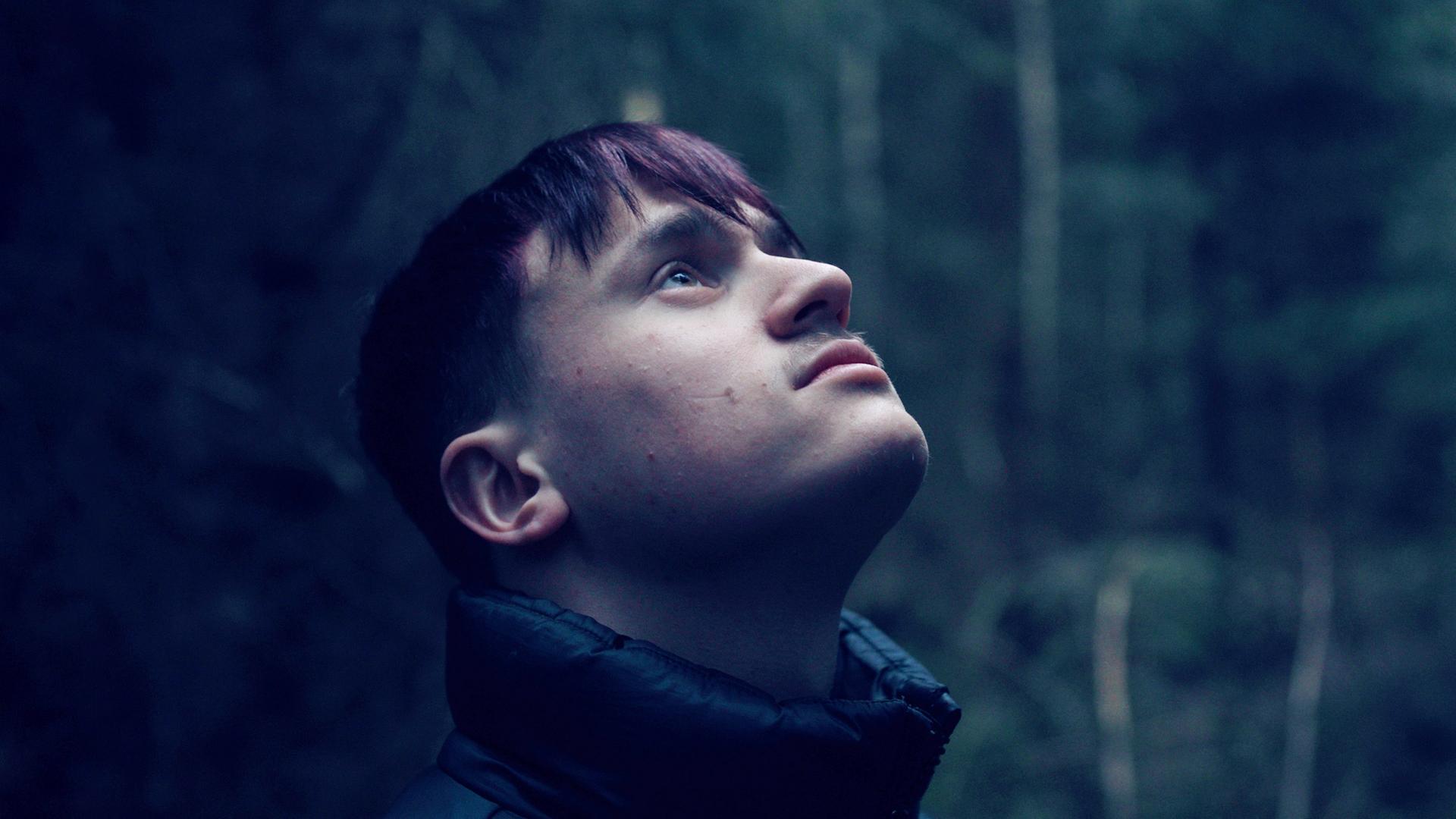 Nahaufnahme eines jungen Mannes, der nach oben blickt.