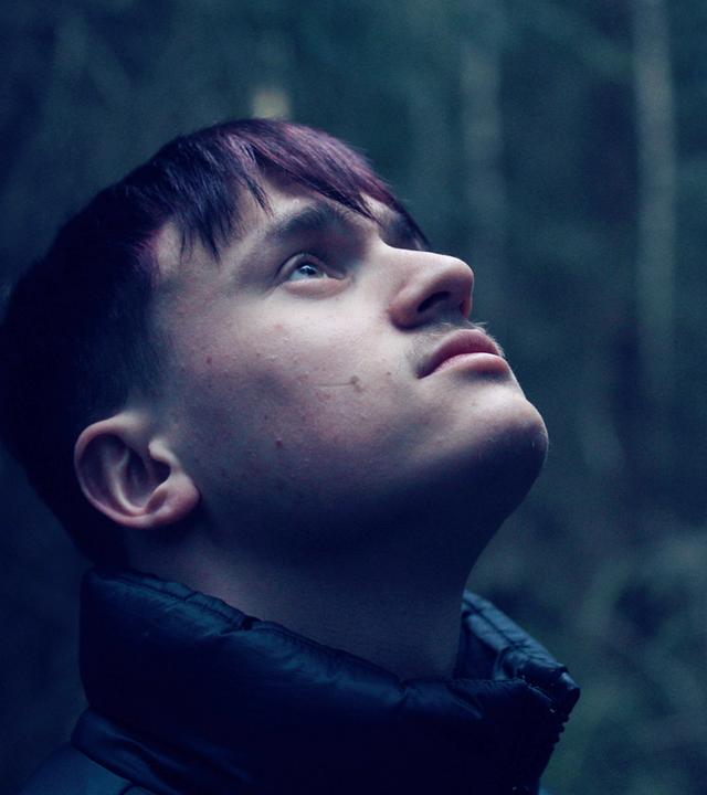 Nahaufnahme eines jungen Mannes, der nach oben blickt.