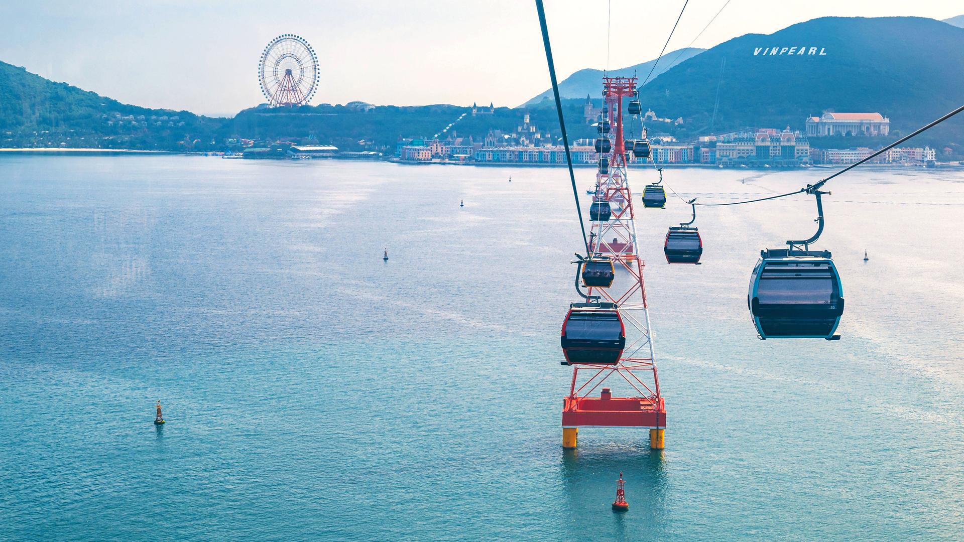 Kabinen-Seilbahn mit mehreren Kabinen schwebt über das Meer zur Hon-Tre-Insel in Vietnam