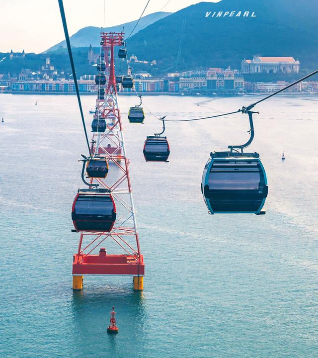 Kabinen-Seilbahn mit mehreren Kabinen schwebt über das Meer zur Hon-Tre-Insel in Vietnam