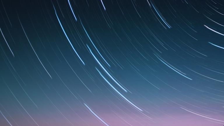 Abstraktes Bild: Zeitrafferaufnahme Sternenhimmel mit Sternenlichtern, die zu Streifen werden