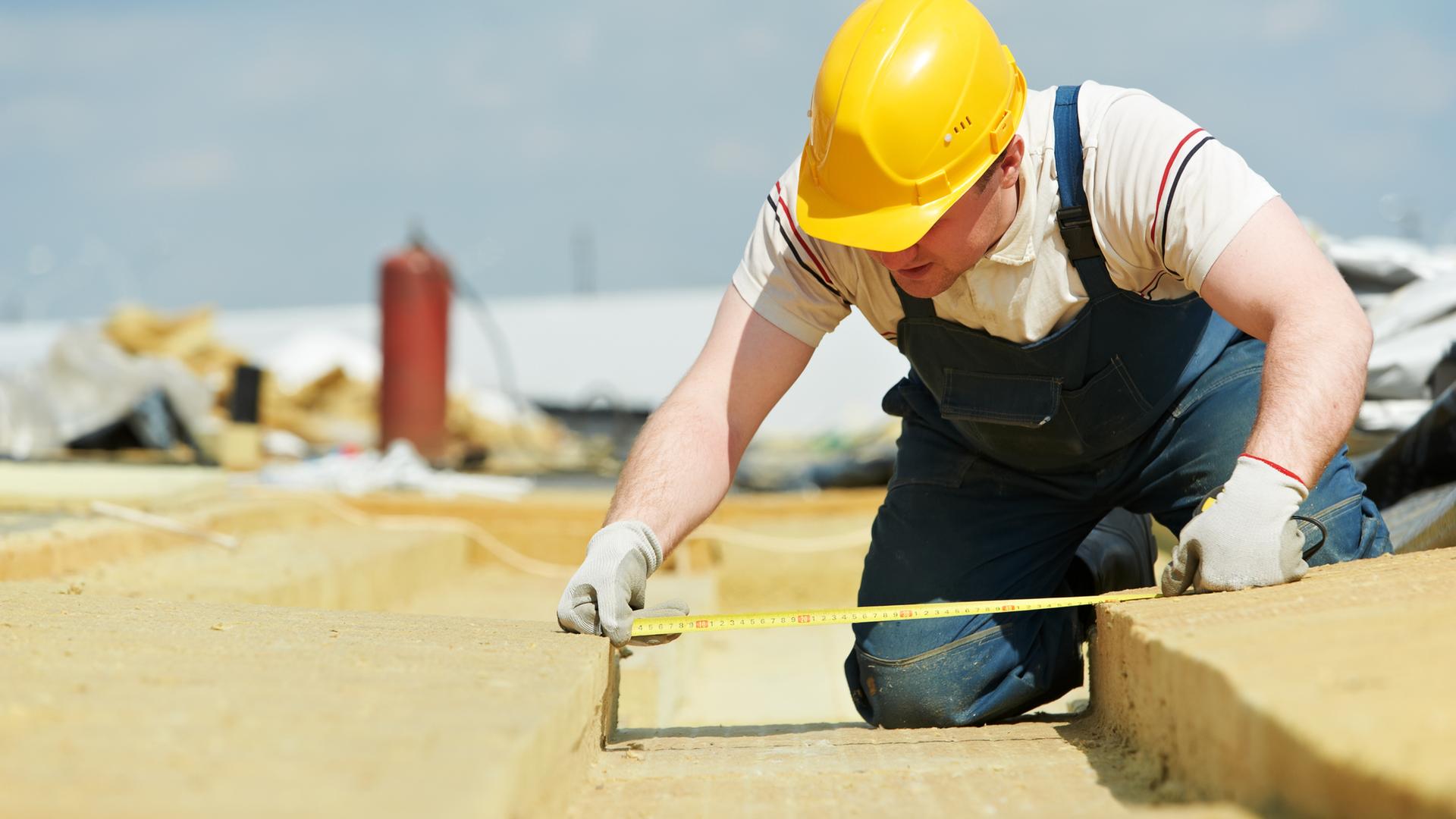 Bauarbeiter misst Dinge aus