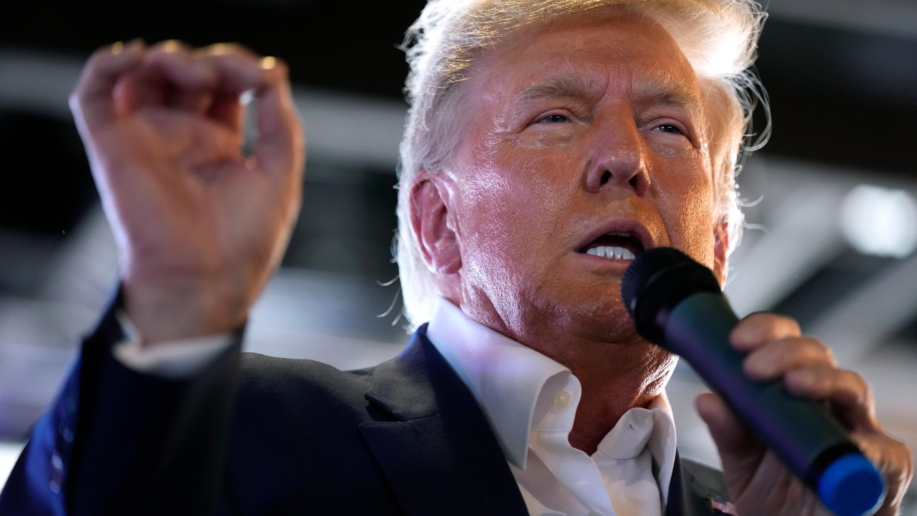 Donald Trump spricht auf einer Wahlkampfveranstaltung in ein Mikrofon
