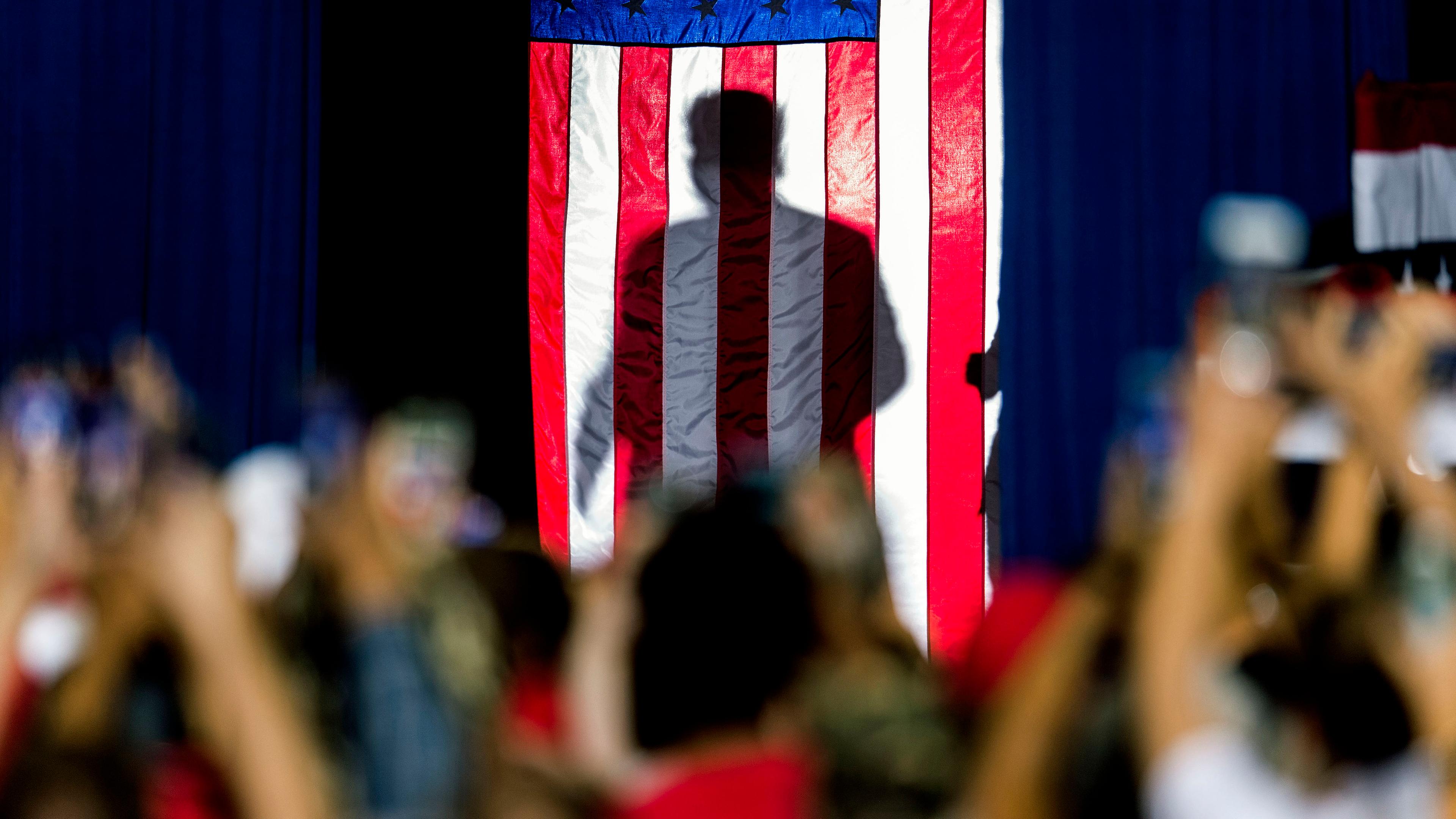 Die Silhouette von Donald Trump scheint durch US-Flagge