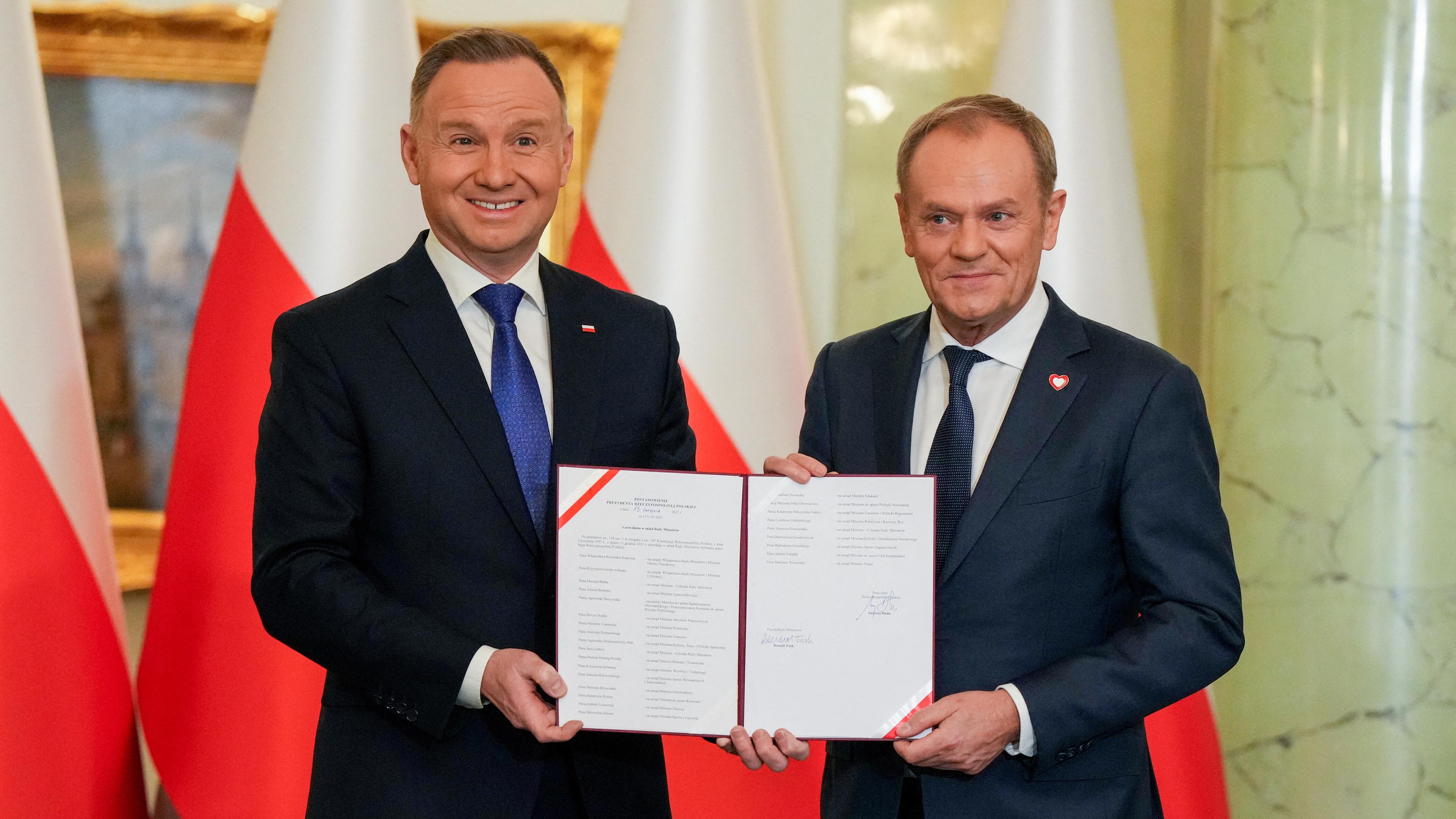 Der polnische Präsident Andrzej Duda und der neu ernannte polnische Premierminister Donald Tusk (R) nehmen an der Vereidigungszeremonie des Kabinetts im Präsidentenpalast in Warschau, aufgenommen am 13.12.2023