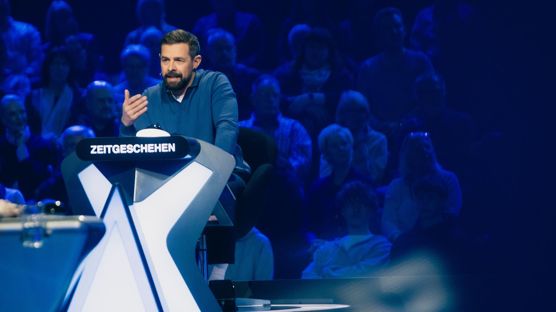 "Der Quiz-Champion": Klaas Heufer-Umlauf sitzt am Ratepult im Studio und gestikuliert.