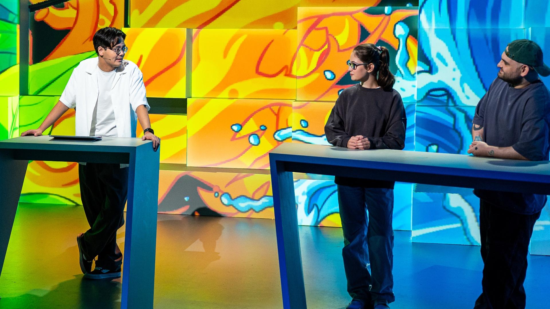 Tanoshii: Die Creator DrawingLikeASir und Fenja sowie Lavina und Azizkazama stehen an den Spielpulten im Tanoshii-Studio. In der Mitte steht Raafey an seinem Pult.