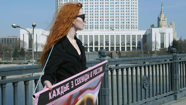 Drei Engel für Russland - Glaube, Hoffnung, Liebe: Natalia Moskwitina demonstriert mit einem Plakat.