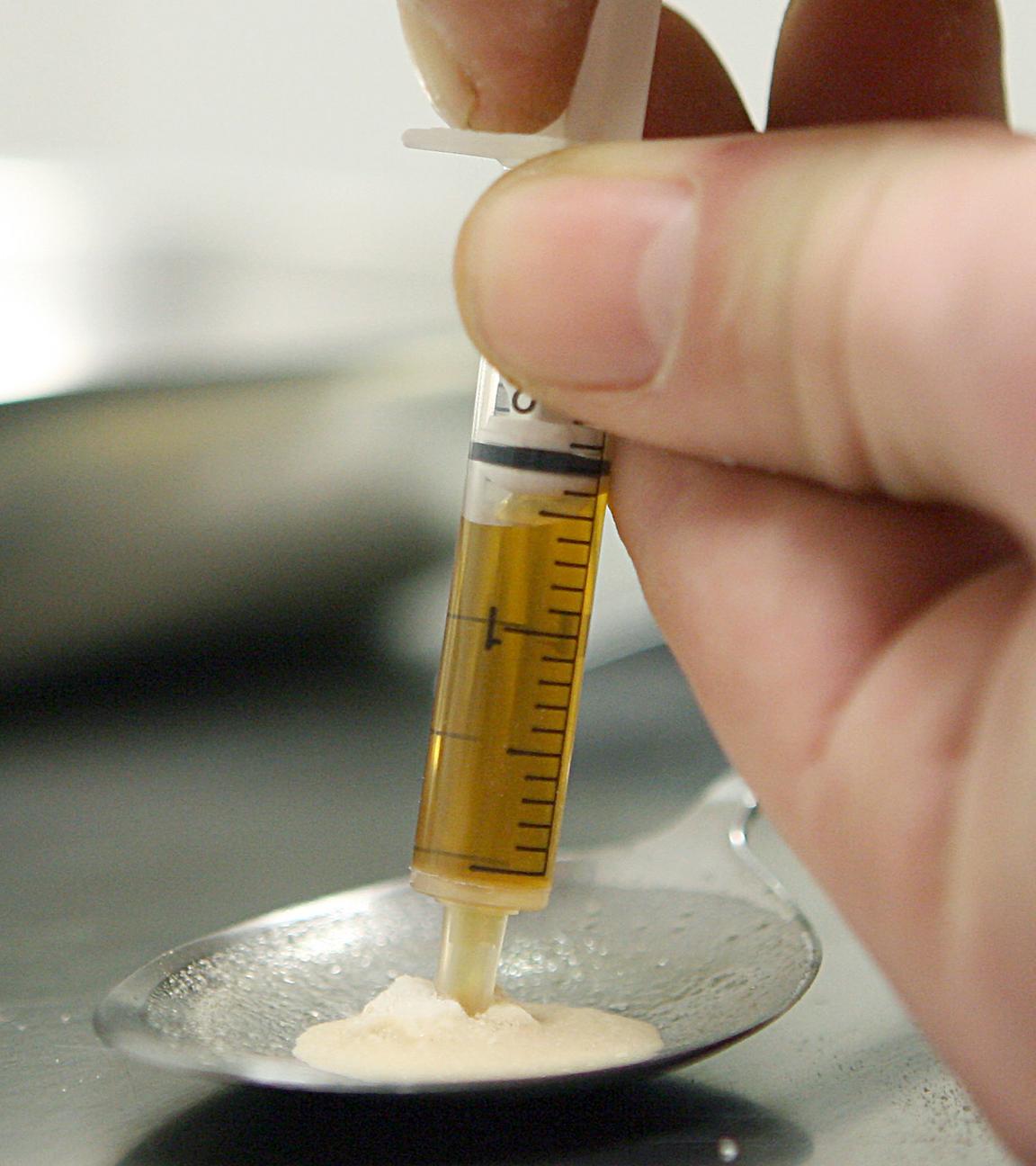 Ein Drogenkonsument zieht im Druckraum der Aids-Hilfe in Frankfurt am Main Heroin in eine Spritze, aufgenommen am 25.01.2007
