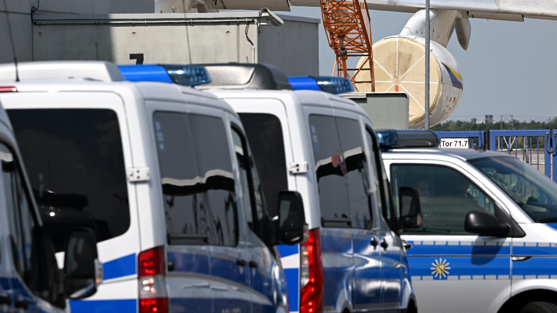 Einsatzfahrzeuge der Polizei stehen in der Nähe eines ukrainischen Flugzeugs auf dem Flughafen Leipzig/Halle.