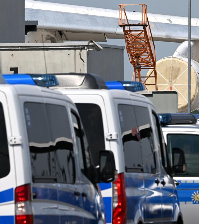  Einsatzfahrzeuge der Polizei stehen in der Nähe eines ukrainischen Flugzeugs auf dem Flughafen Leipzig/Halle.