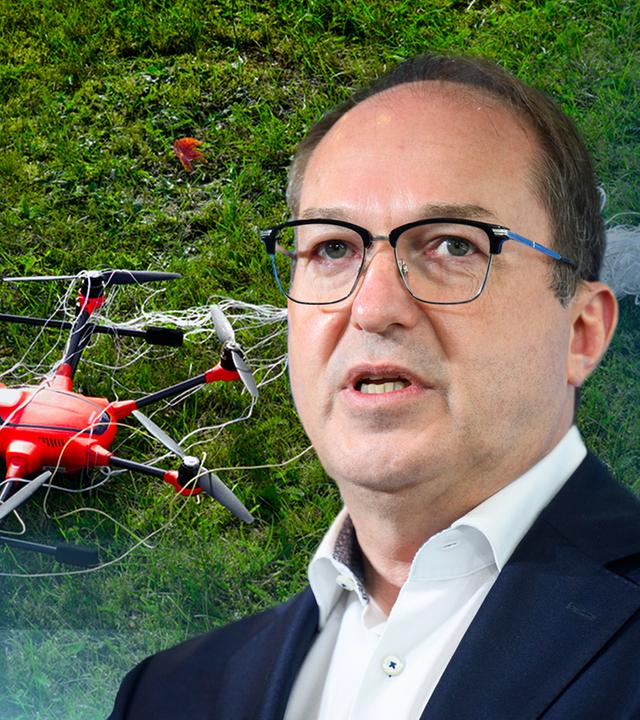 Innenminister Dobrindt vor einer Grafik mit einer kleinen, auf einer Wiese liegenden Drohne.