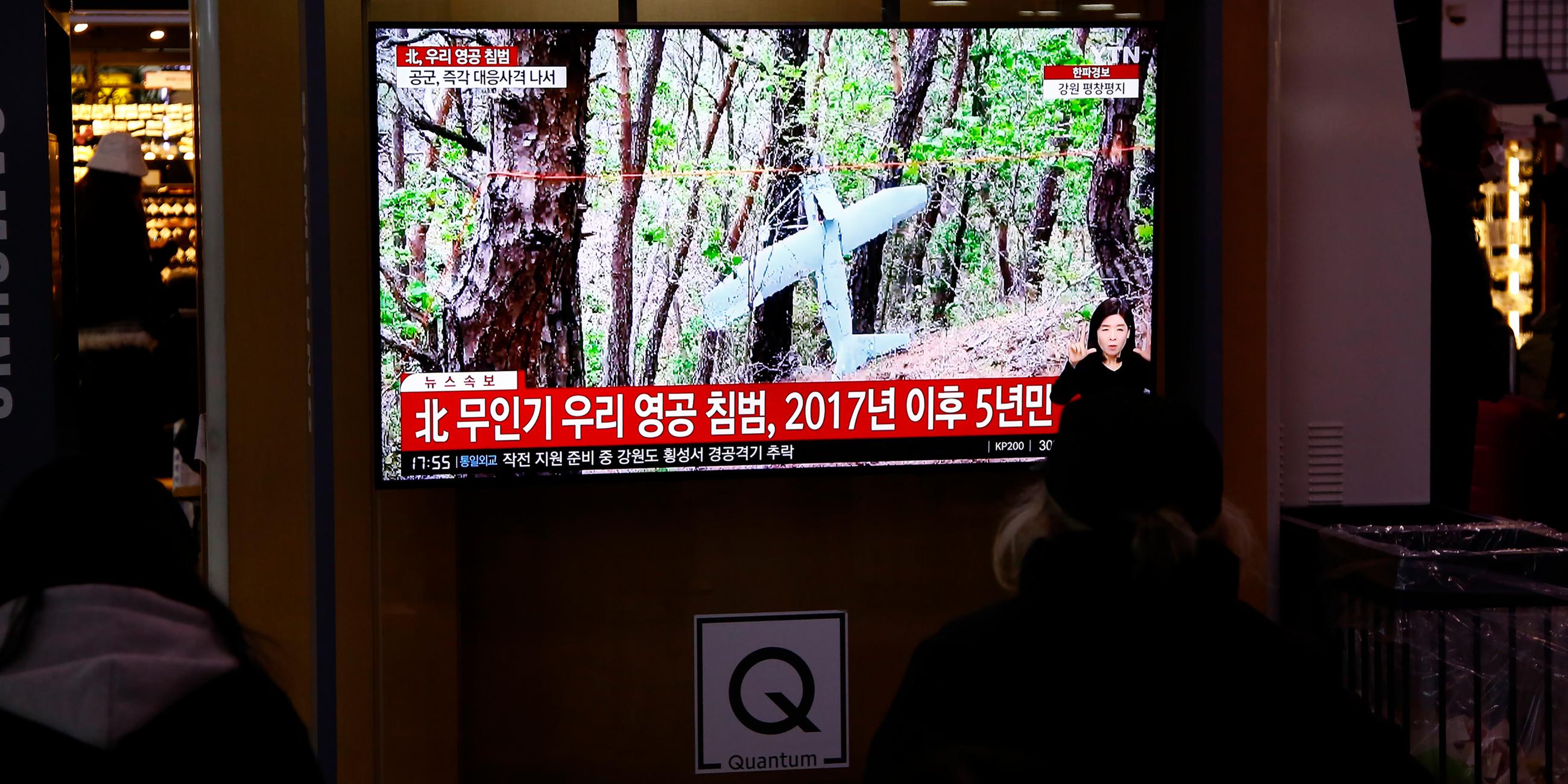 Menschen sehen TV-Nachrichten an einem öffentlichen Bildschirm in Seoul.