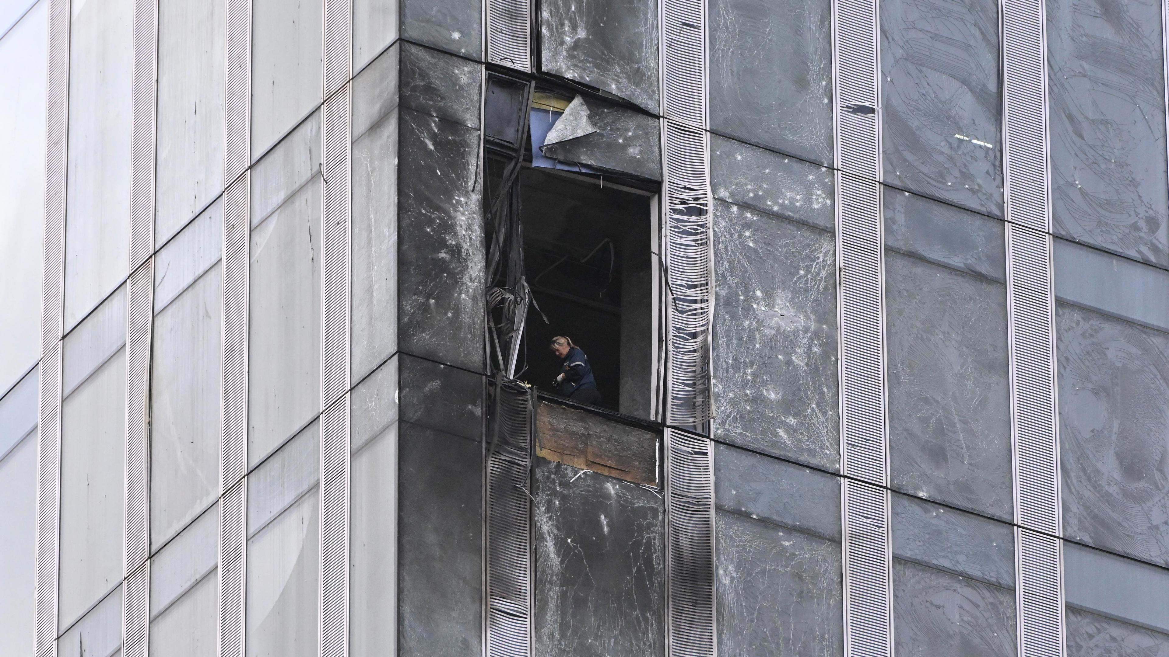 Ein Ermittler untersucht einen beschädigten Wolkenkratzer nach einem Drohnenangriff in Moskau, aufgenommen am 23.08.2023