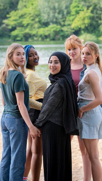 Mia, Sam, Amira, Hannah und Kiki stehen vor einem Badesee