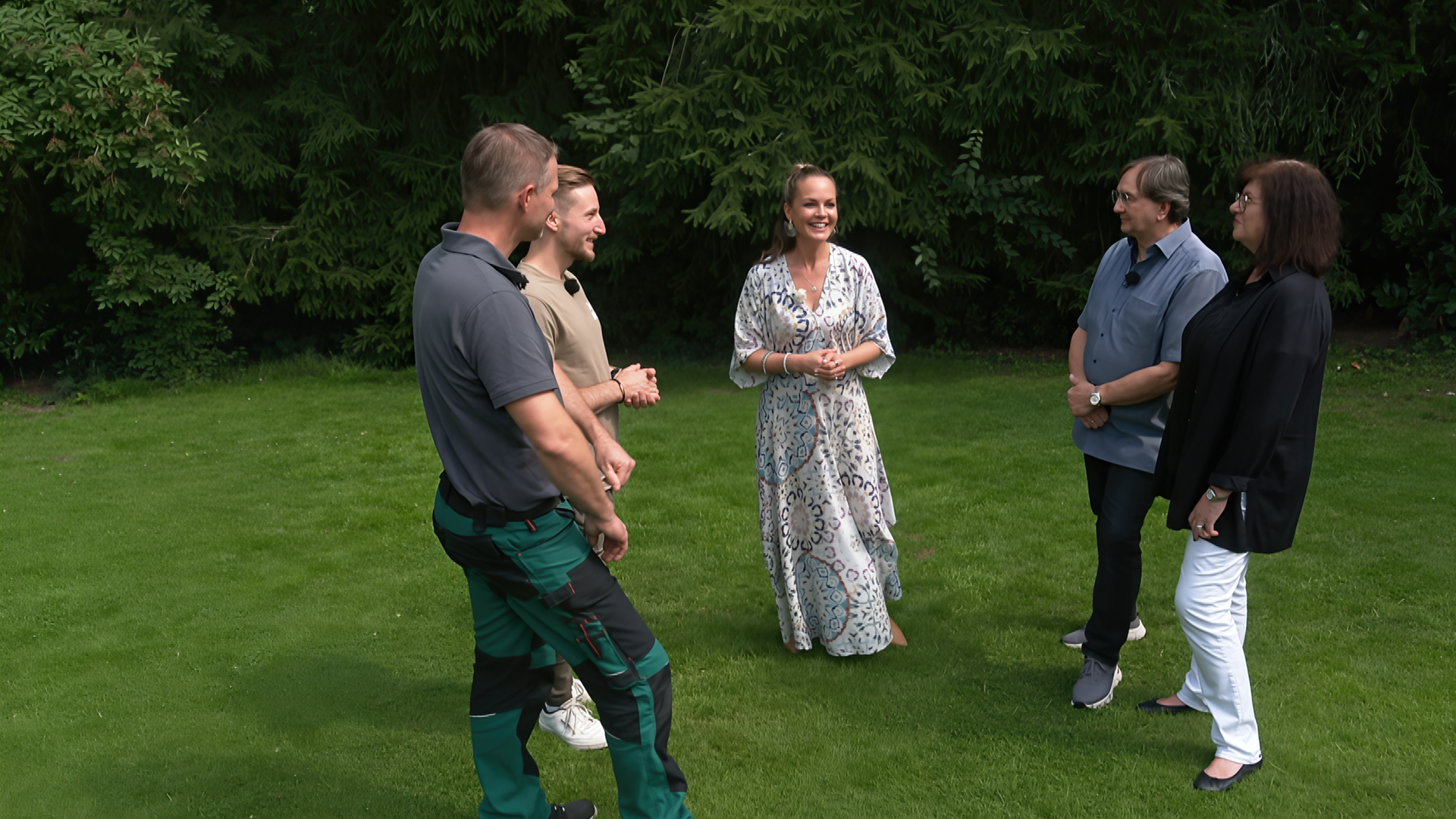 Eva Brenner steht mit ihren zwei Gartenprofis und Birgit und Uwe Schäfer auf einer Grünfläche.