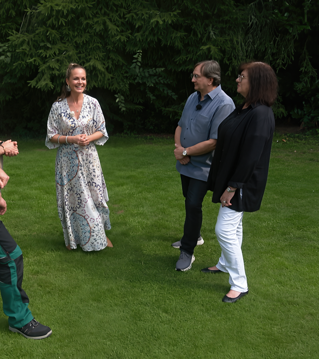 Eva Brenner steht mit ihren zwei Gartenprofis und Birgit und Uwe Schäfer auf einer Grünfläche.