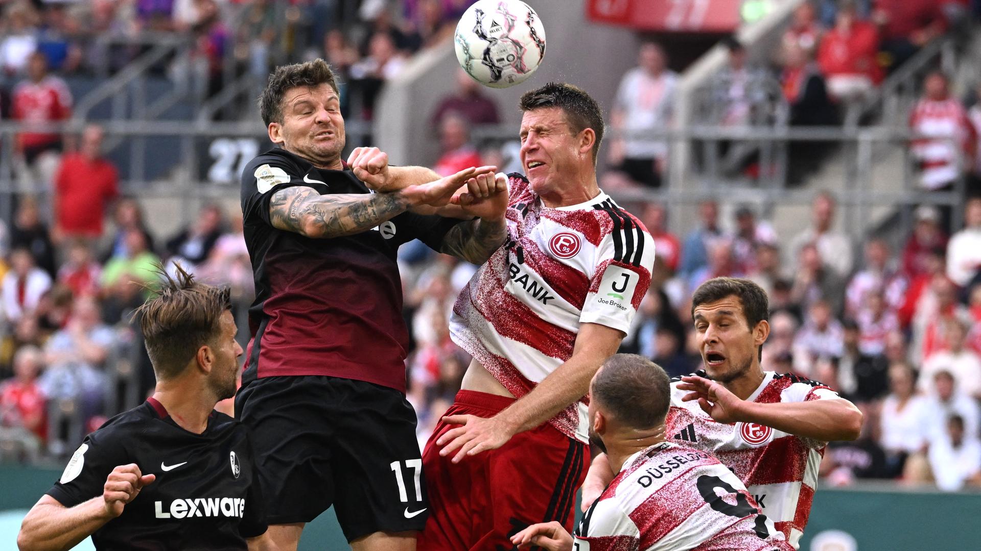 Lukas Kübler (l., SC Freiburg) und Dominique Heintz (r., Fortuna Düsseldorf) kämpfen im DFB-Pokal um den Ball.