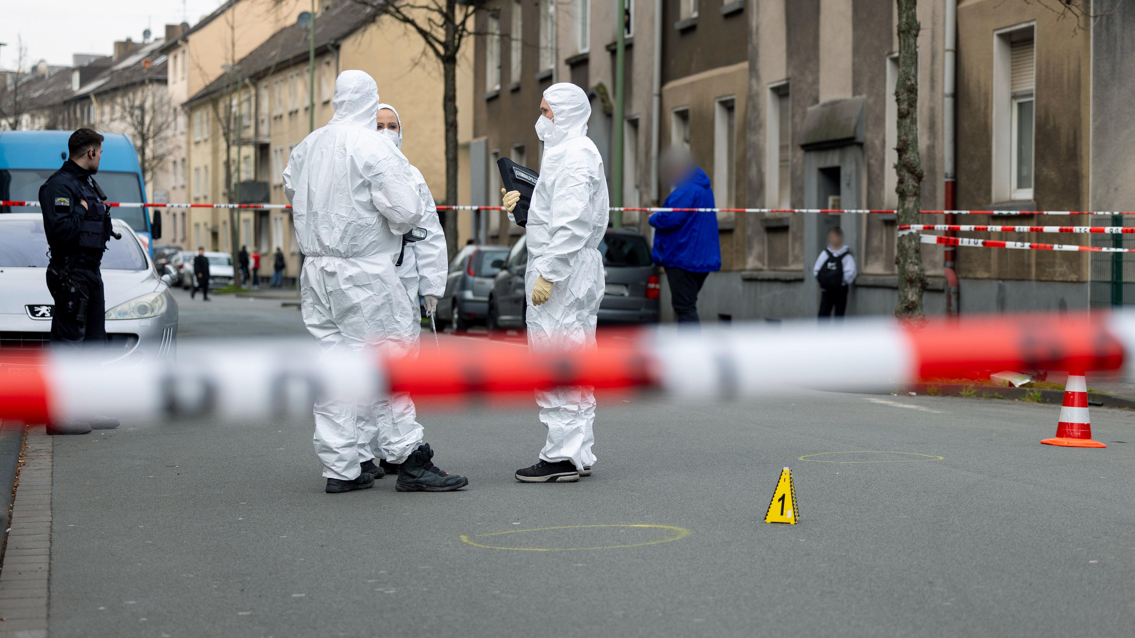 Beamte der Spurensicherung stehen am Tatort des Angriffs auf zwei Kinder, einige Meter von einer Schule in Duisburg entfernt.