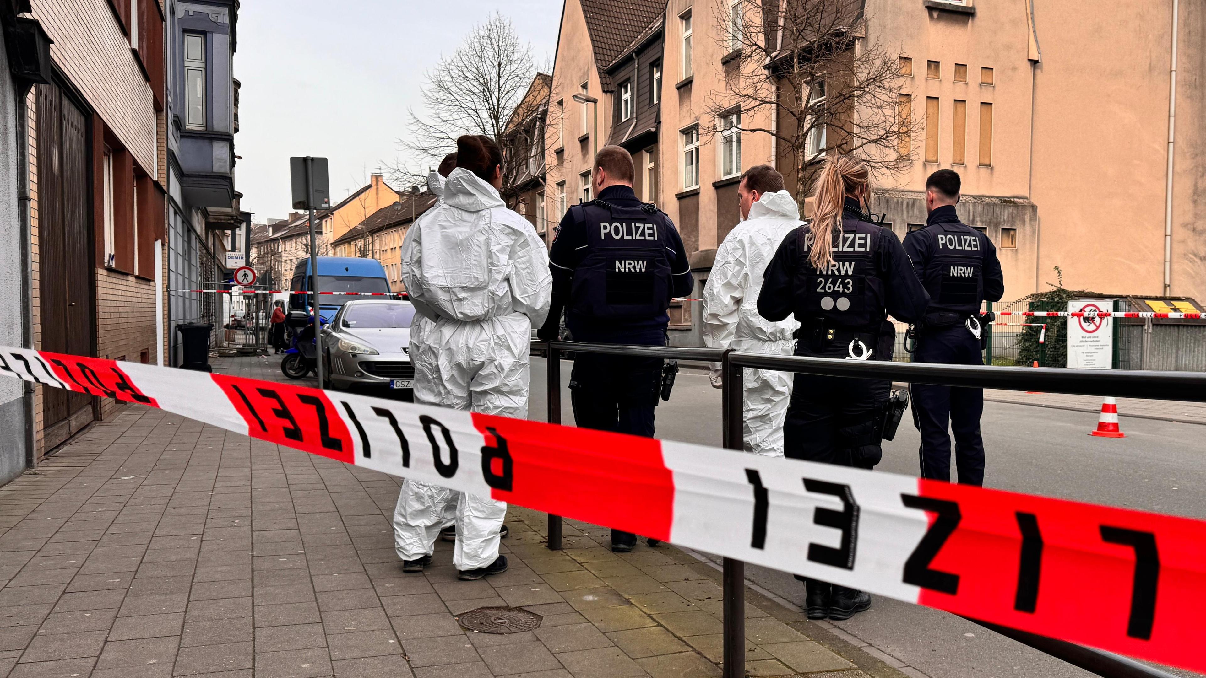 Nordrhein-Westfalen, Duisburg: Beamte stehen an einem abgesperrten Tatort.
